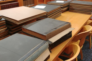Stacks of large volumes on a wooden table