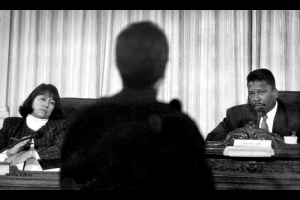 Left, Adrienne Benavidez and Chet Whye, both seated, face Lt. Gary Leuthauser at a Public Safety Review Commission meeting.