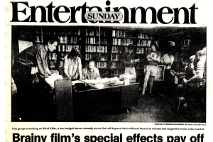 Clip from Rocky Mountain News article titled "Brainy film's special effects pay off." The image is six people standing in front of bookcases in Central Library basement with camera crew.