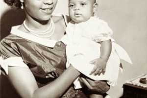 Mother poses with her infant daughter for a family portrait