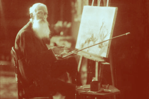 A man sits at an easel painting