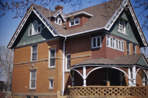 View of the Henry Lee House (1880) at 32nd (Thirty-Second) Avenue and Clay Street in the Highland neighborhood, Denver, Colorado. The three story brick Queen Anne Style house has a large wraparound porch, trimmed in red sandstone. The house has a steeped front gable with verge board and decorative shingling.  The house is part of the Potter Highlands historic district and a Denver Landmark.