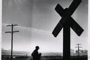 A farmer stands next to the battered railroad crossing sign four days after the tragedy. The crossing had no flashing lights or automatic arms, just two road signs to warn motorists. (BILL PEERY/ROCKY MOUNTAIN NEWS/1961)