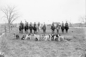 Women pose on horseback by a pack of hunting dogs in Colorado.