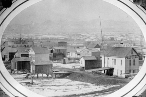 A view of the earliest Rocky Mountain News building in Denver, Colorado. The building was built on stilts in the bed of Cherry Creek, but the building, equipment, and many early issues of the News were lost in the flood of 1864. Photograph taken by an unknown photographer between 1859 and 1864.