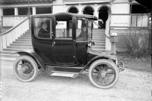 Mr. and Mrs. Harry and Addie Mellon Rhoads, parents of Harry M. Rhoads sit inside an electric automobile in front of City Park pavilion, Denver, Colorado.