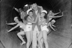 A man poses with women dancers in matching costumes and shoes inside a revolving tube ride at Lakeside Amusement Park in Denver, Colorado.