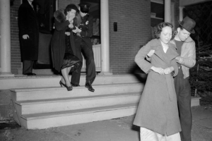 Two women are escorted from a home in Denver. One women is being led out by a police officer and the other woman is being led out by a man in plain clothes. They may be leaving the scene of a murder or suicide.