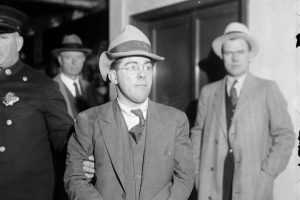 An unidentified man in handcuffs is escorted by a police officer, probably in Denver, Colorado.