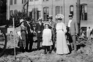 Group portrait of men, women, and girls in Denver, Colorado, at the ground breaking ceremony for the Denver Public Library, including (l to r): Jean Dudley, F. M. Richie, Mr. Frederick Ross (architect), Mr. C. R. Dudley, Helen F. Ingersoll, B. H. Lichter (contractor)[?], and Marion Dudley (in front).
