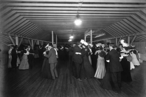 Interior view of a dance hall at Manhattan Beach amusement park in Denver, Colorado; shows men and women dancing.