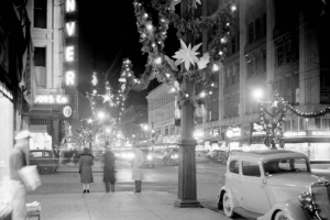 Nighttime view of 16th (Sixteenth) Street in downtown Denver, Colorado. Streetlights are decorated with greenery and Christmas lights.