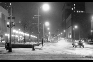 Nighttime view of 16th (Sixteenth) Street during a snow storm in downtown Denver, Colorado. Automobiles are on the street; shows Joslins department store. The Security Life Building is in the distance.
