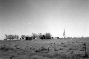 View of the terrain that surrounds the area in which the Sand Creek Massacre took place, November 29 and 30, 1864, in Kiowa County, Colorado; United States troops killed some 200 Native Americans (Cheyenne and Arapaho), two thirds of whom were women and children. A farm house, windmill, and utility buildings stand on an open prairie landscape.