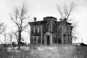 View of the John B. Hindry home on North Washington Street in Denver, Colorado; shows a house with quoins, bay window, portico, and a cornice.