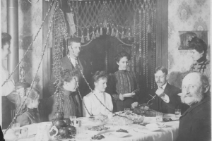 George Leitch prepares to carve a turkey on Thanksgiving in his house at 2957 Humboldt Street in Denver, Colorado. May, men, women, and a girl look on.