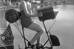 A woman sits on a bicycle-shaped peddle boat by Lake Rhoda at Lakeside Amusement Park in Lakeside (Jefferson County), Colorado.