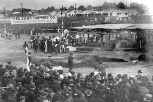A crowd of people surrounding people barbecuing at the Denver Union Stockyard