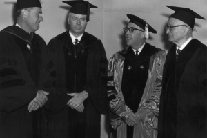 Men pose in graduation gowns and mortarboards with tassels at the  University of Colorado at Boulder.