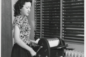 Photograph of Charles Boettcher School student June Goodrich, age 18, working at a mimeograph at the Charles Boettcher School in Denver, Colorado.